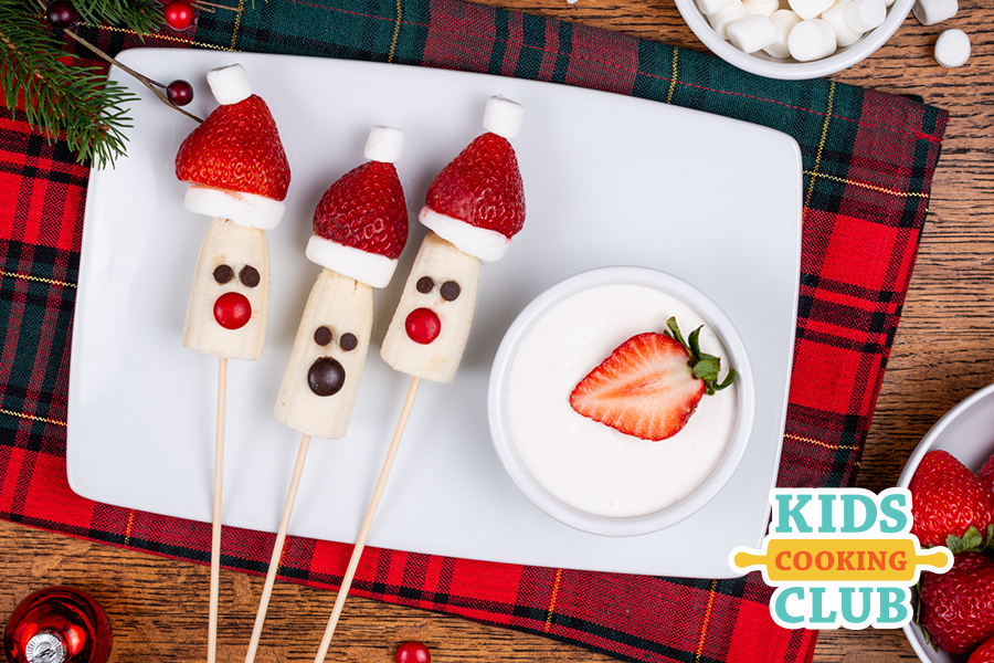 Banana santas on a skewer made with bananas, strawberries as hats and candies for eyes and nose