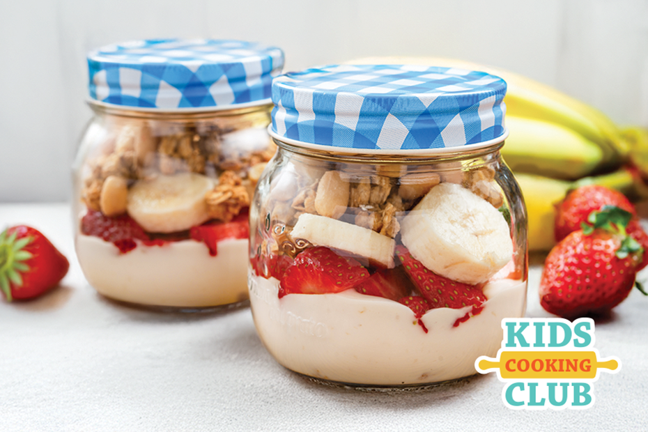strawberry and banana parfait in a jar on a table. Logo: Mini-club de cuisine