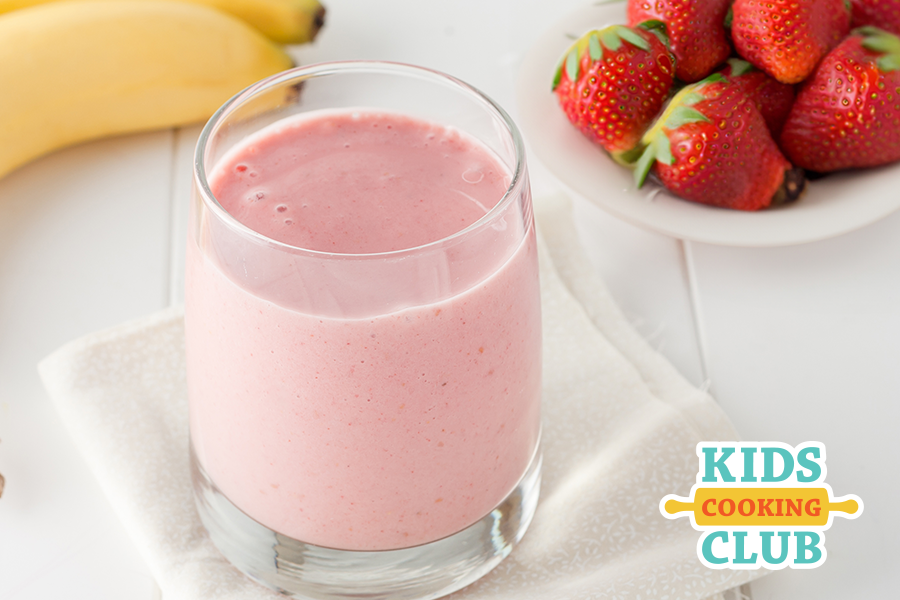 strawberry banana smoothie in a glass on a kitchen counter with fresh strawberries and bananas